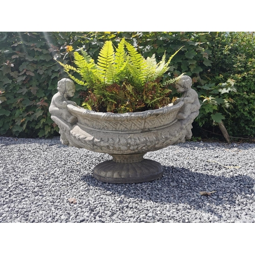 654 - Oval moulded stone urn decorated with cherubs seated above lion's masks. {70 cm H x 90 cm W x 55 cm ... 