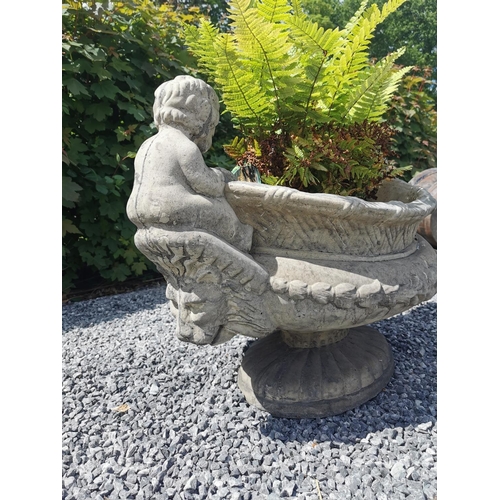 654 - Oval moulded stone urn decorated with cherubs seated above lion's masks. {70 cm H x 90 cm W x 55 cm ... 