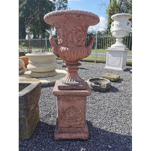 669 - Pair of good quality moulded terracotta urns decorated with swags on pedestals in the Georgian manne... 