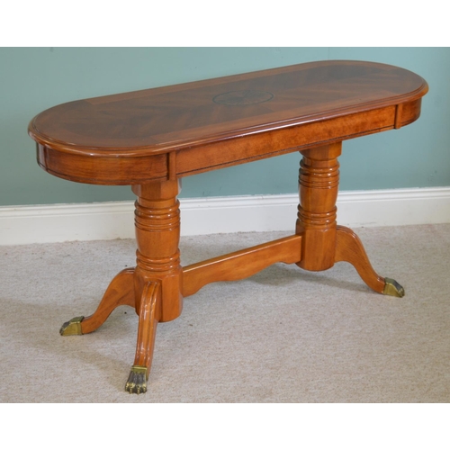 712 - Walnut oval coffee table raised on turned supports and four out swept legs in the Regency style { 65... 