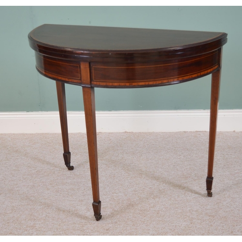 823 - Edwardian inlaid mahogany demi  - lune turn over leaf games table raised on tapered square legs. { 7... 