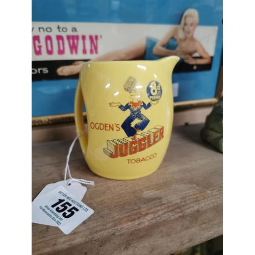 155 - Ogden's Juggler Tobacco advertising jug. 8 pence per ounce. {11 cm H x 10 cm W x 9 cm D}.