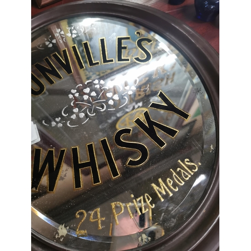 631 - Dunville's Whiskey oval advertising mirror with original brass frame. {44 cm H x 38 cm W}.