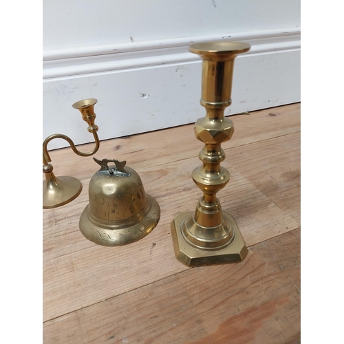 24 - Three brass candlesticks and brass bell {18 cm, 14 cm & 7 cm H}.