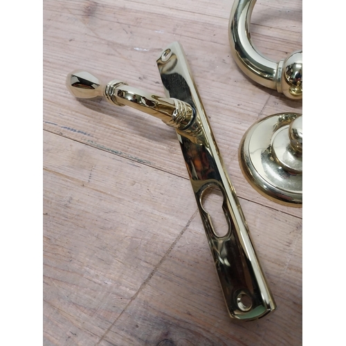27 - Collection of brass door furniture including knocker and two handles {Knocker 14 cm H x 14 cm W and ... 