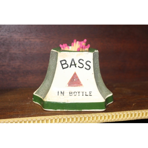 124 - Bass in bottle ceramic match strike and holder. { 7 cm H x 10 cm W x 10 cm D}.