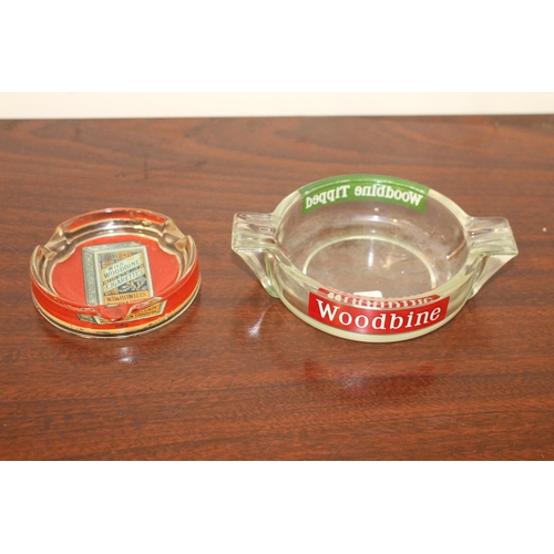 142 - Two Woodbine Cigarettes glass advertising ashtrays. {2 cm H x 10 cm Diam} and {4 cm H x 17 cm W x 13... 