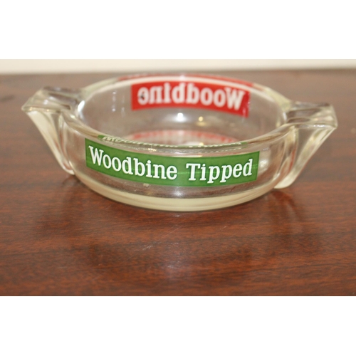 142 - Two Woodbine Cigarettes glass advertising ashtrays. {2 cm H x 10 cm Diam} and {4 cm H x 17 cm W x 13... 