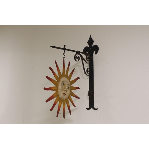 144 - Sunburst metal hanging sign mounted on metal bracket {54 cm H x 15 cm W x 38 cm D}.