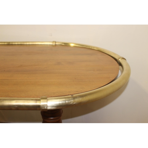 214 - Oak oval drinks stand with brass hand rail and brass foot rest. { 106 cm H x 178 cm W x 108 cm D}.