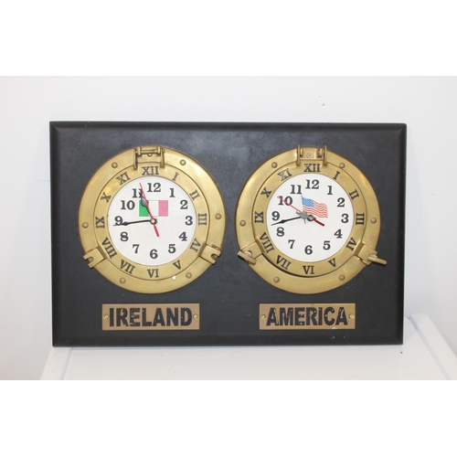 306 - Brass Ireland and America clocks mounted on wooden board {74 cm H x 63 cm W}.