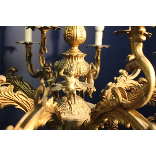 322 - Bronze eight branch chandelier decorated with cherubs and scrolls {H 73cm x Dia 85cm}.