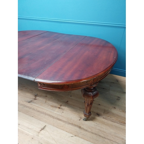 349 - 19th C. mahogany extendable dining table raised on fluted legs and brass castors with five leaves {8... 