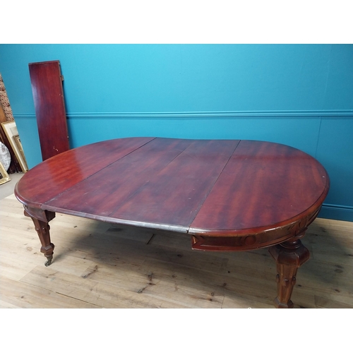 349 - 19th C. mahogany extendable dining table raised on fluted legs and brass castors with five leaves {8... 