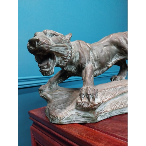 380 - Bronzed terracotta model of lion on craggy rock. {25 cm H x 41 cm W x 18 cm D}.