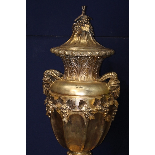 270A - Large gold lidded urn decorated with rams heads on base {H 206cm x D 70cm}.