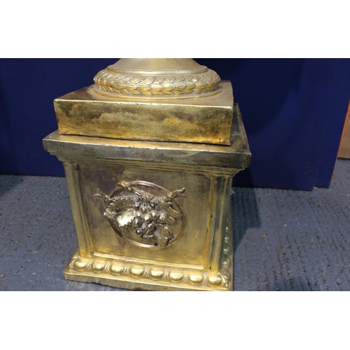 270A - Large gold lidded urn decorated with rams heads on base {H 206cm x D 70cm}.