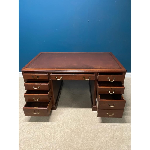 250A - Mahogany knee holed desk the tooled leather top above a centre drawer flanked by eight short drawers... 