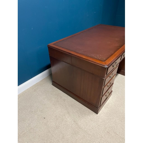 250A - Mahogany knee holed desk the tooled leather top above a centre drawer flanked by eight short drawers... 