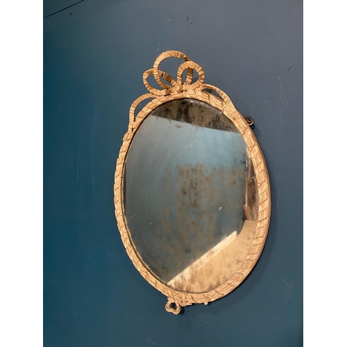 300A - Georgian painted oval mirror with original glass surmounted with bows.  { 73 cm H X 52 cm W }.