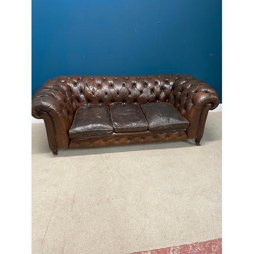 325 - Deep buttoned leather upholstered chesterfield sofa raised on tapered  feet. { 74 cm H X 200 cm W  X... 