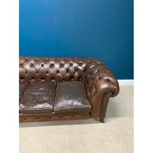 325 - Deep buttoned leather upholstered chesterfield sofa raised on tapered  feet. { 74 cm H X 200 cm W  X... 