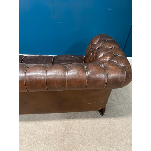 325 - Deep buttoned leather upholstered chesterfield sofa raised on tapered  feet. { 74 cm H X 200 cm W  X... 