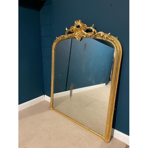 86 - Victorian decorative gilt overmantle mirror surmounted with foliage and with bevelled plate. { 180 c... 