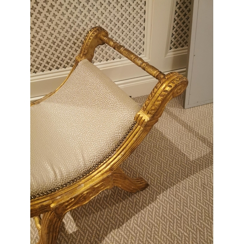 303A - Giltwood upholstered stool raised on x- framed supports.