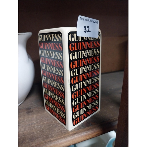 32 - Two ceramic Guinness advertising lighters and pepper pot. {13 cm H x 7 cm W x 7 cm D}.