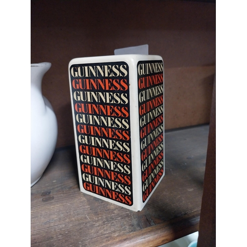 32 - Two ceramic Guinness advertising lighters and pepper pot. {13 cm H x 7 cm W x 7 cm D}.