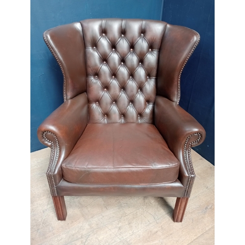 103 - Brown leather deep button wingback chair raised on square legs {H 95cm x W 85cm x D 65cm }.