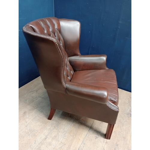 103 - Brown leather deep button wingback chair raised on square legs {H 95cm x W 85cm x D 65cm }.