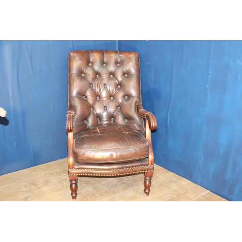 109 - Brown leather deep buttoned armchair raised on turned legs {H 95cm x W 85cm x D 65cm }.