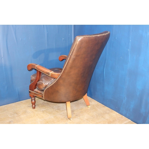 109 - Brown leather deep buttoned armchair raised on turned legs {H 95cm x W 85cm x D 65cm }.