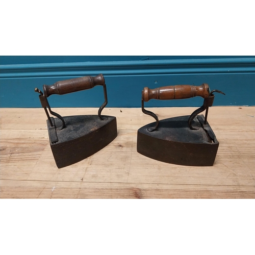 121 - Pair of early 20th C. irons with turned wooden handles {17 cm H x 17 cm W x 11 cm D}.