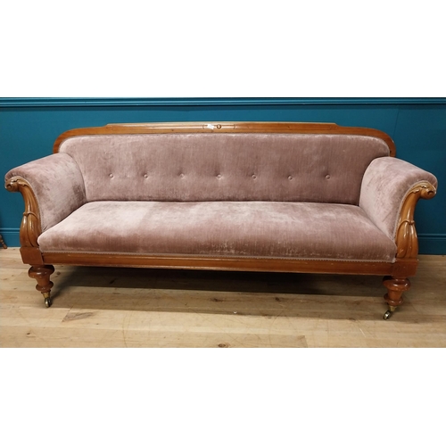 141 - Victorian mahogany and upholstered three seater sofa raised on turned legs and brass castors {87 cm ... 