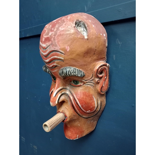 213 - Hand carved wooden mask with blowpipe  {H 53cm x W 27cm x D 15cm }.