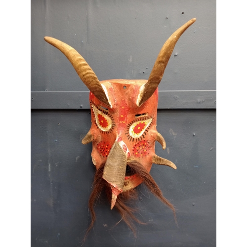 219 - Hand carved wooden mask with horns and beard  {H 43cm x W 26cm x D 20 cm}.