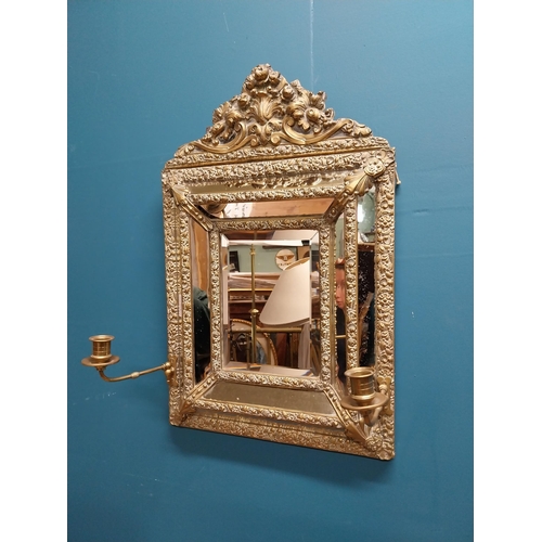 245 - Victorian embossed brass cushion mirror with candle holders {60 cm H x 40 cm W x 20 cm D}.