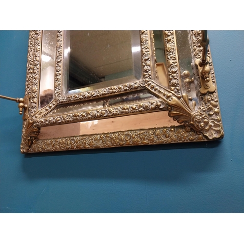 245 - Victorian embossed brass cushion mirror with candle holders {60 cm H x 40 cm W x 20 cm D}.