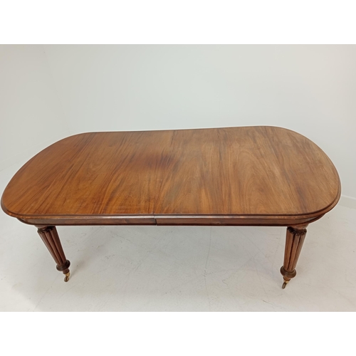 263 - Mahogany extendable table raised on turned reeded legs. {75cm H x 200cm W x 106cm D and 242cm W with... 