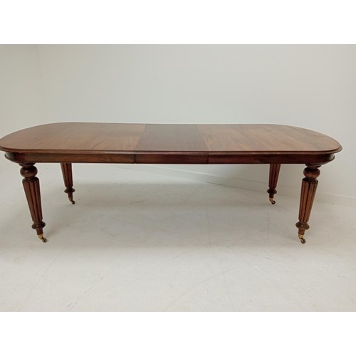 263 - Mahogany extendable table raised on turned reeded legs. {75cm H x 200cm W x 106cm D and 242cm W with... 