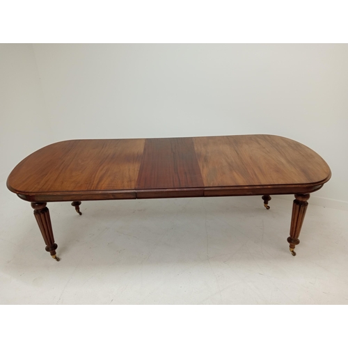 263 - Mahogany extendable table raised on turned reeded legs. {75cm H x 200cm W x 106cm D and 242cm W with... 