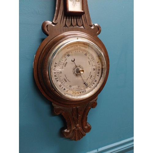 295 - Edwardian carved oak barometer with silvered dial {75 cm H x 24 cm W}.