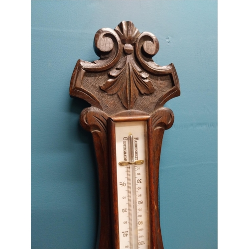 295 - Edwardian carved oak barometer with silvered dial {75 cm H x 24 cm W}.