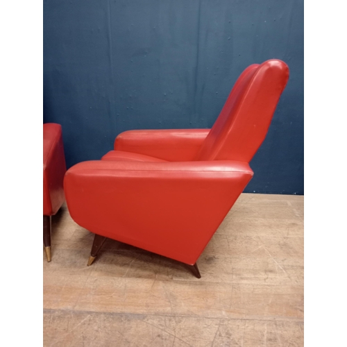 343 - Pair of Retro red leather armchairs raised on mahogany and brass legs.