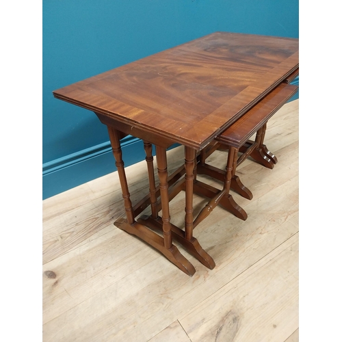 357 - Mahogany nest of three tables raised on turned columns and platform feet {48 cm H x 76 cm W x 41 cm ... 