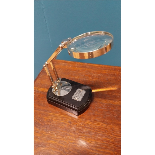 36 - Chrome and ebonised table magnifying glass {18 cm H x 18 cm W x 9 cm D}.