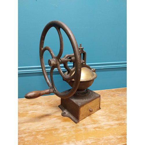 425 - Early 20th C. cast iron and brass wheel coffee grinder {50 cm H x 40 cm W x 34 cm D}.